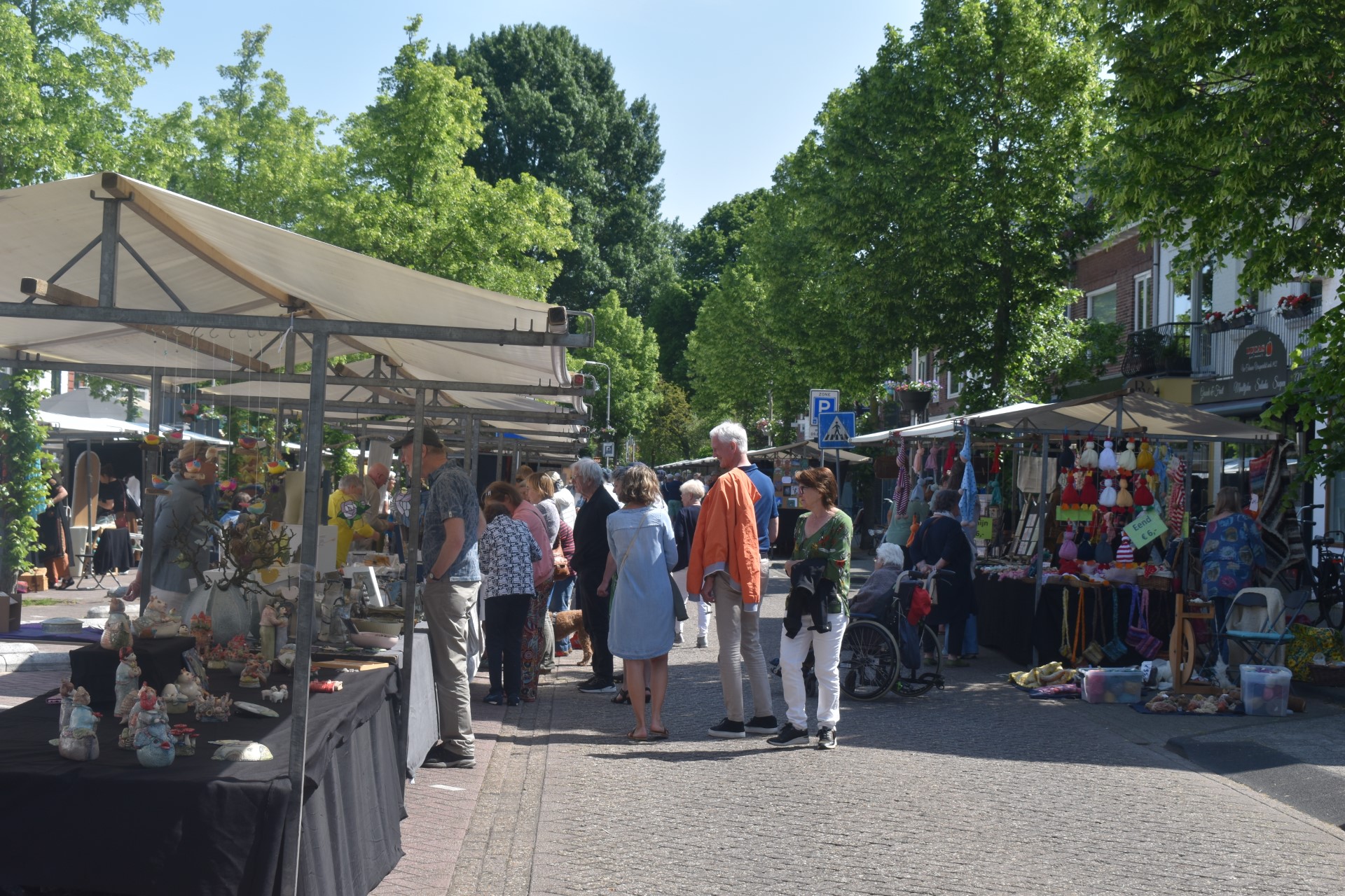Tevreden bezoekers en standhouders op Kunstmarkt Jan van Goyenstraat
