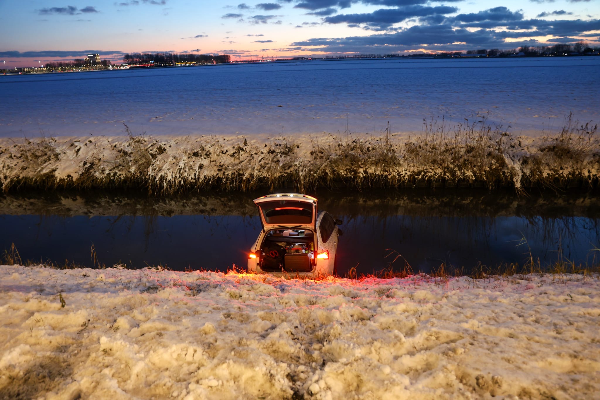 Auto belandt in water door gladheid