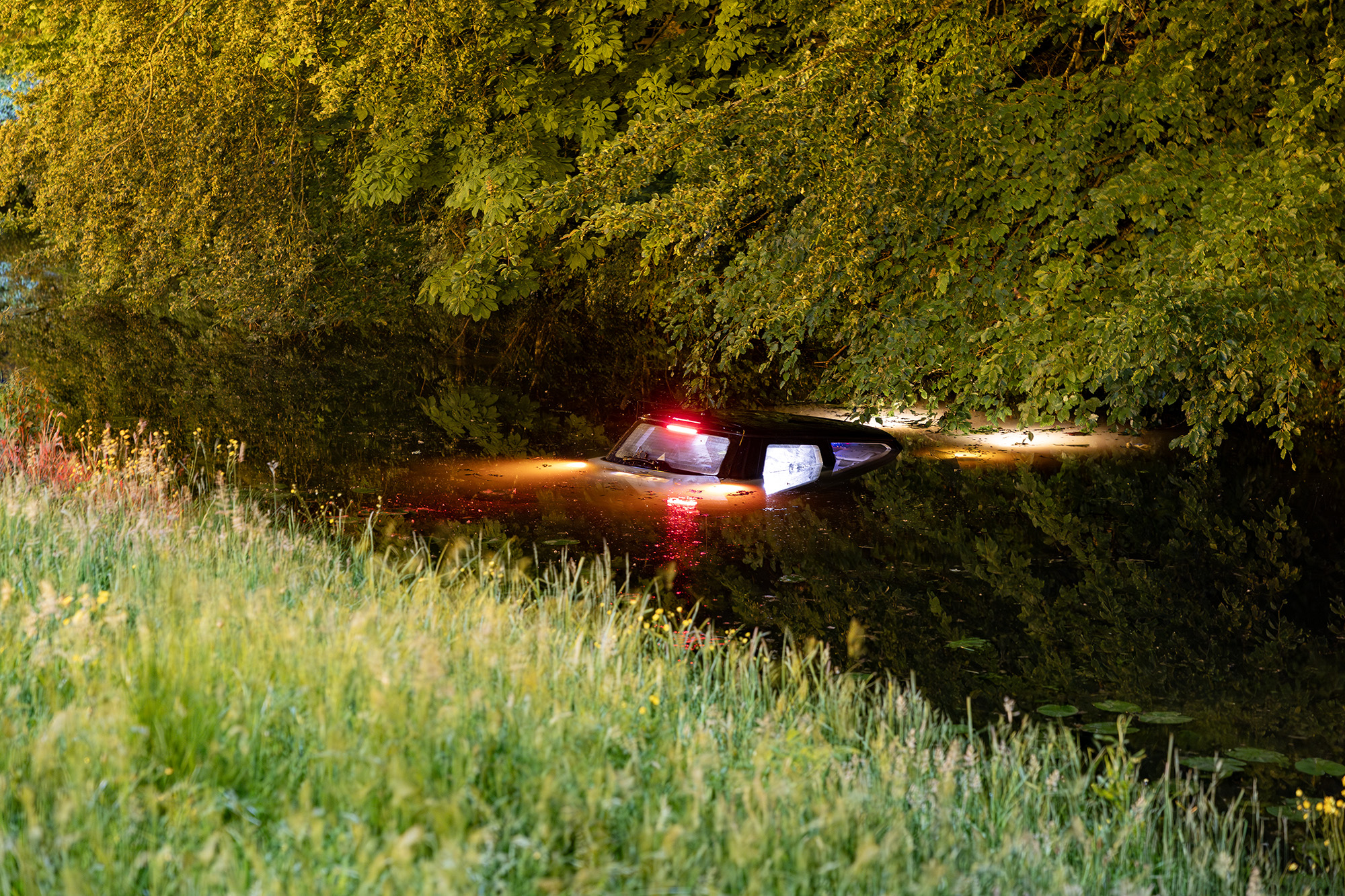 Auto te water, inzittenden met de schrik vrij